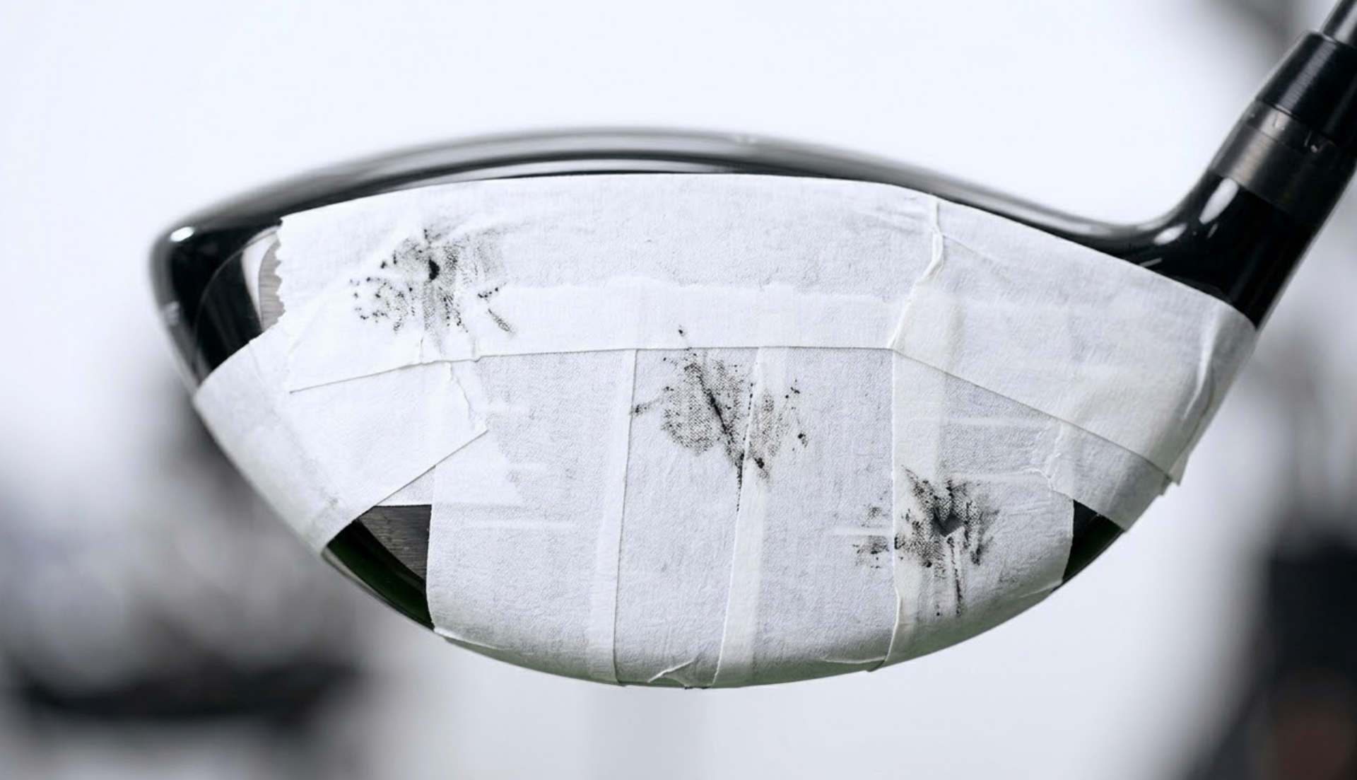 Close-up of driver face with impact tape showing strike marks at high-toe, low-heel, and center positions